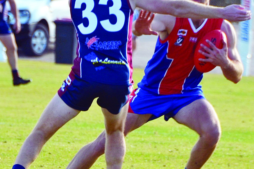 Saint’s Max Hungerford attempts to power his way passed Calder United’s Billy Forrester in the seniors match on Saturday.
